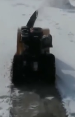 Tracked snow blower clearing snow in action